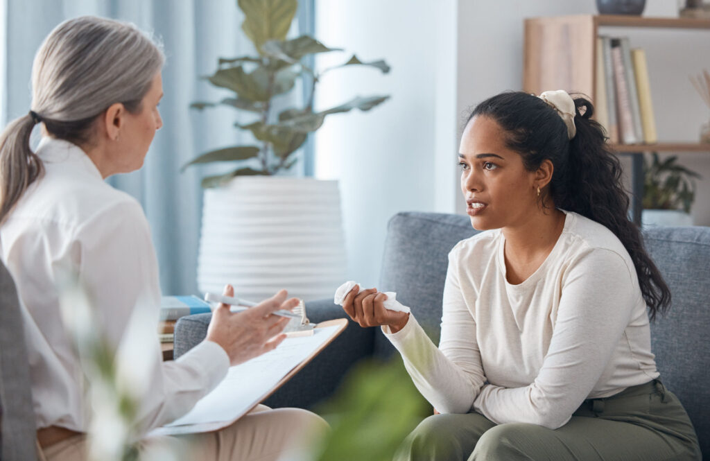 Woman conversing with older woman therapist about inpatient or outpatient treatment