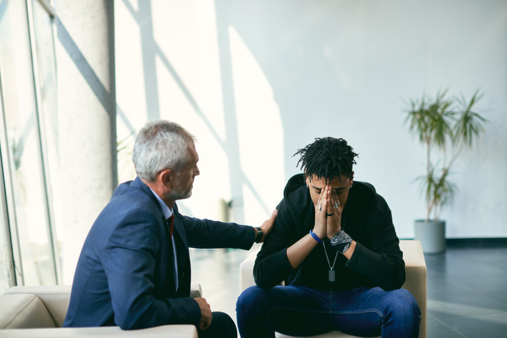 Male therapist reassuring young man regarding quitting vaping