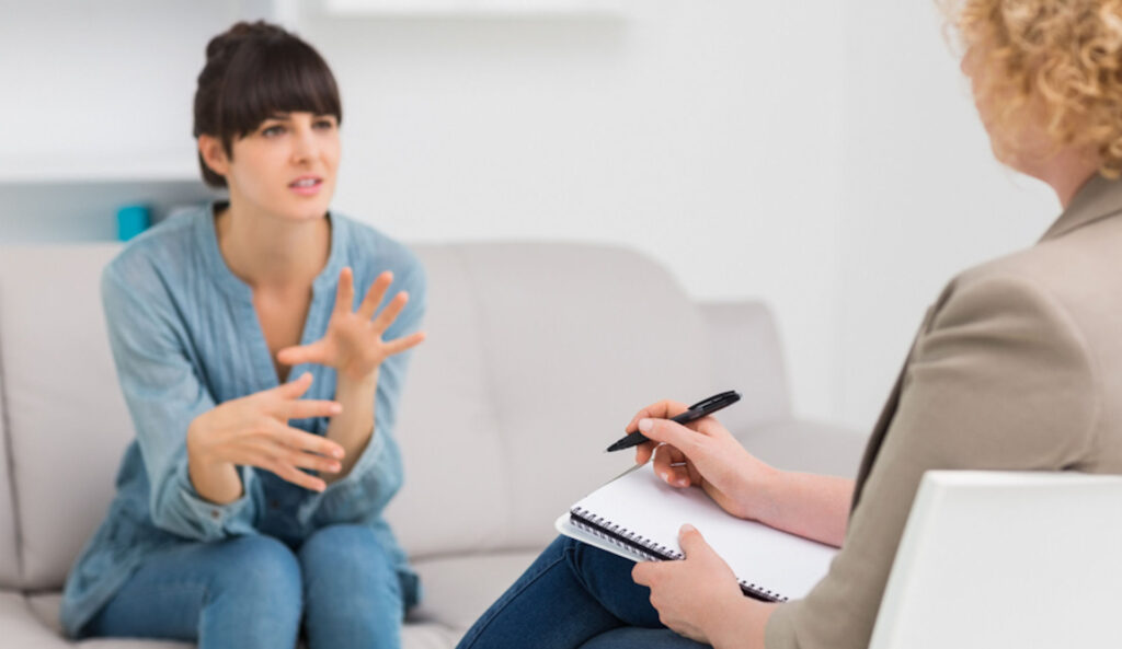 woman sitting on a couch asking therapist about anxiety medication