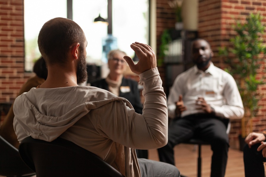 man sitting in a group circle for addiction support group