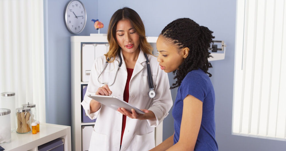 Doctor explaining chart contents to a young woman in a functional doctor's office