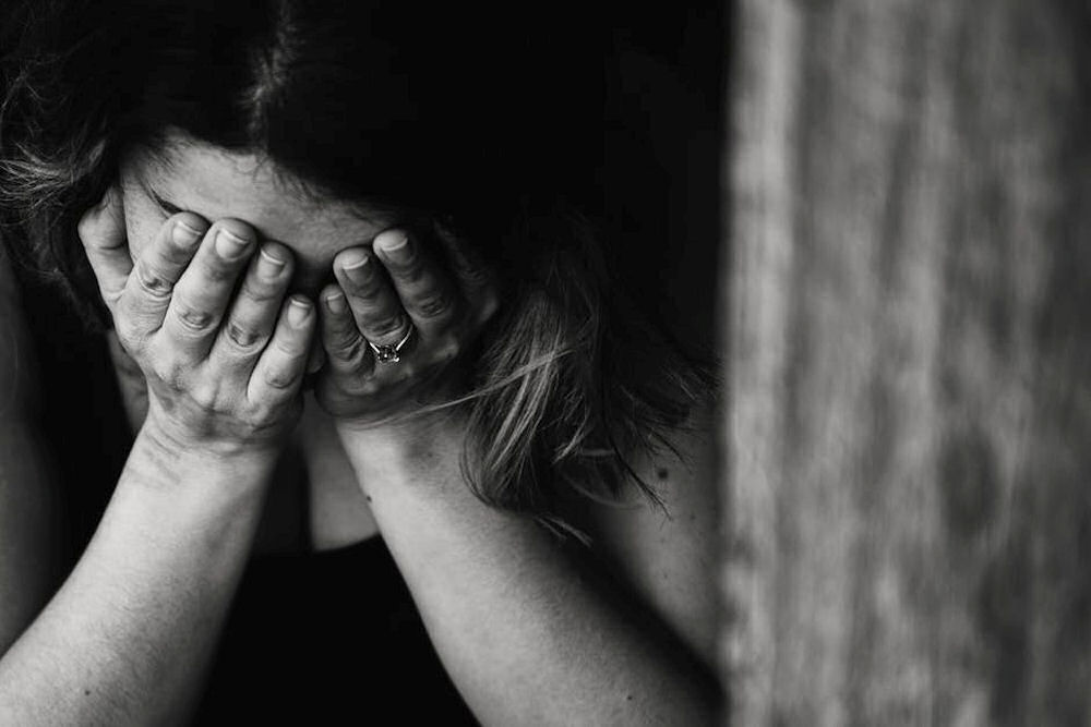 Black and white photo of a woman holding her face in her hands