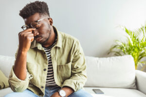 Frustrated man pinching nose while contemplating heroin addiction treatment