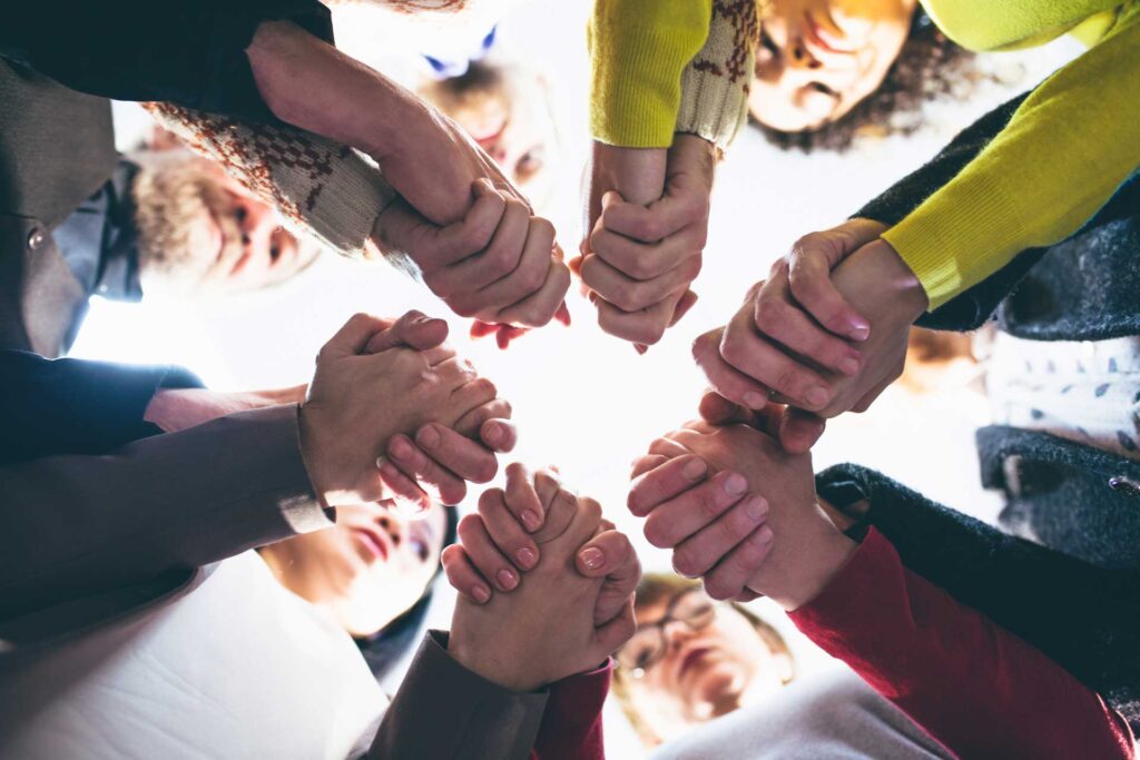 Shot looking up at a family in therapy holding hands in a circle