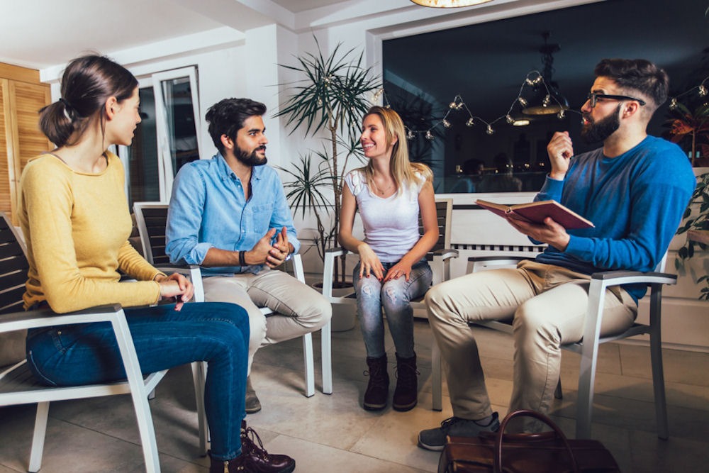 Group discussion about evidence-based practice for addiction moderated by man with notebook