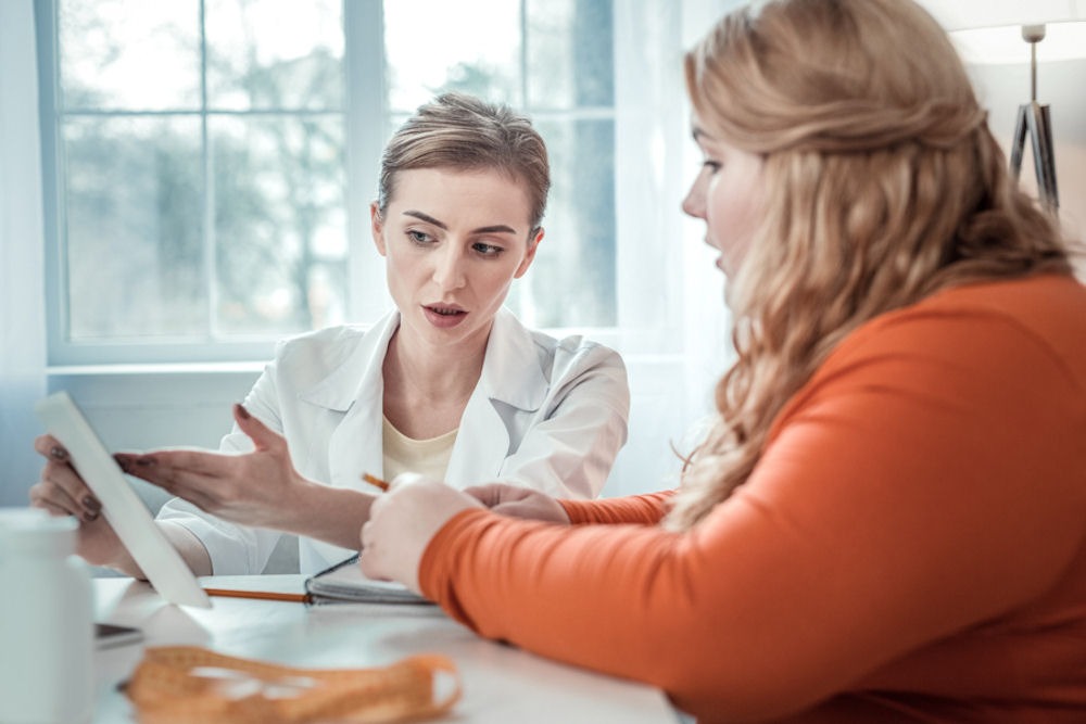 Young woman discussing long-term strategies for coping with addiction with her doctor