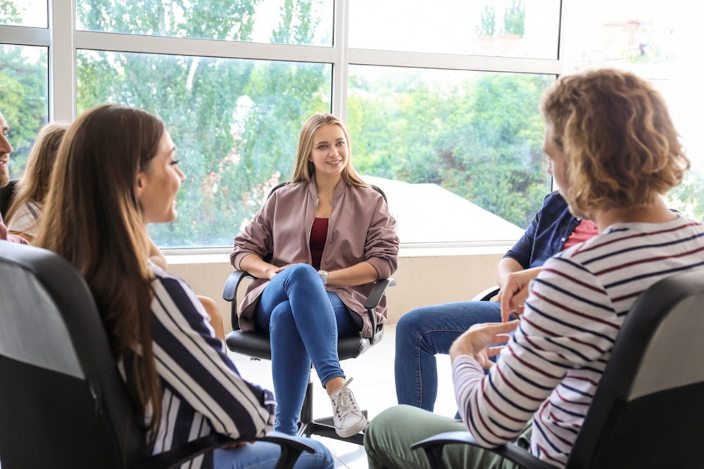 Therapy group of young women talking about hard drugs vs. soft drugs