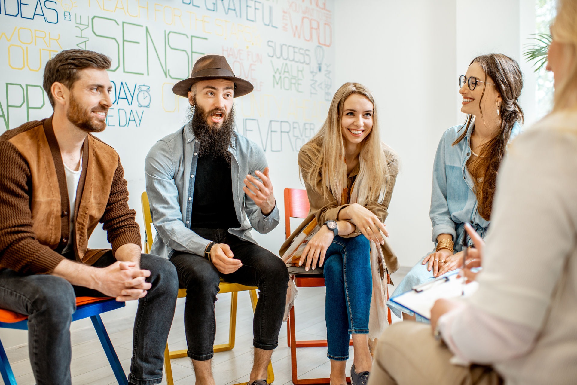 group of people sitting in circle talking and smiling