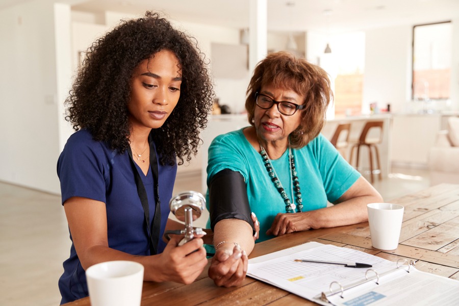 Nurse taking blood pressure of woman going through medical detoxification