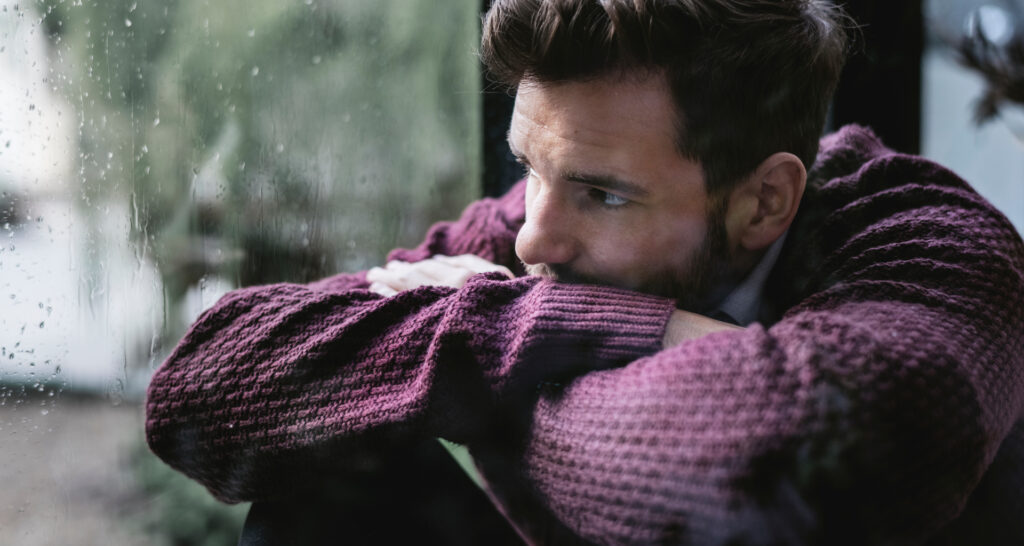 Man looking out the window while thinking about how much fentanyl is lethal