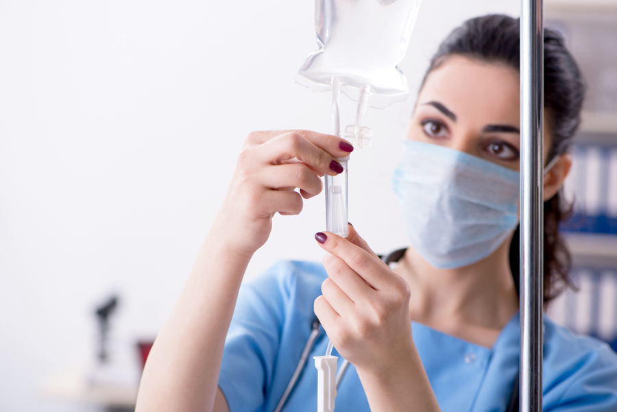 Nurse adding substance to IV bag of someone suffering from ibogaine treatment side effects