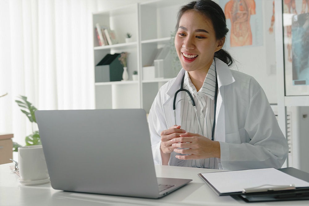 Doctor performing a Zoom medical appointment at desk