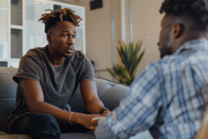 Young man talking to addicted friend who doesn't want help