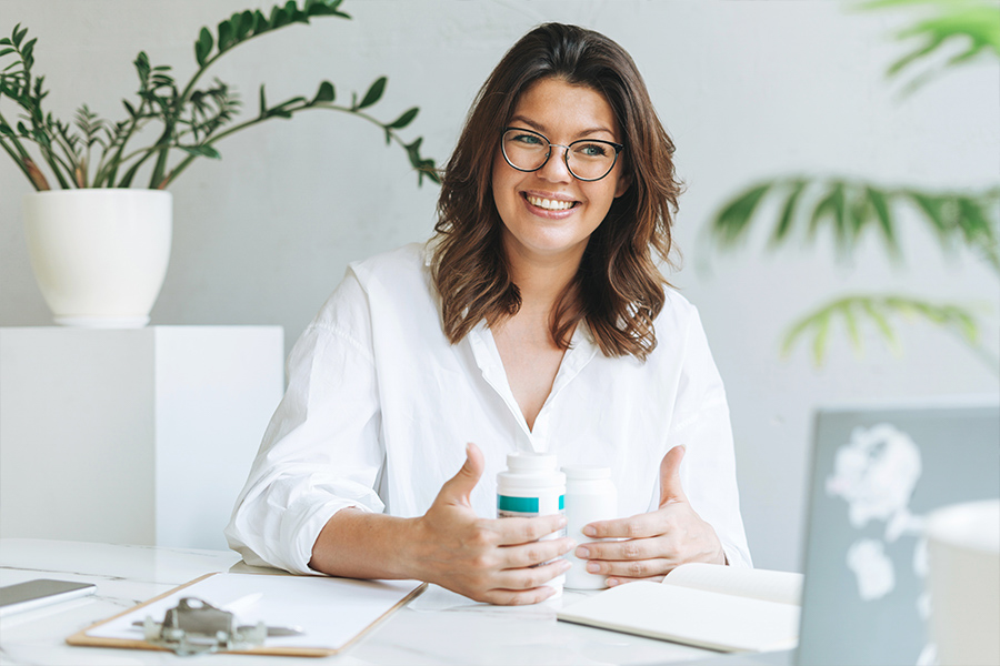 Therapist with water bottle ansering questions from person calling in on a laptop